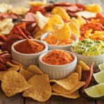 Assortment of gourmet seasoned chips with different spices on a rustic wooden table.