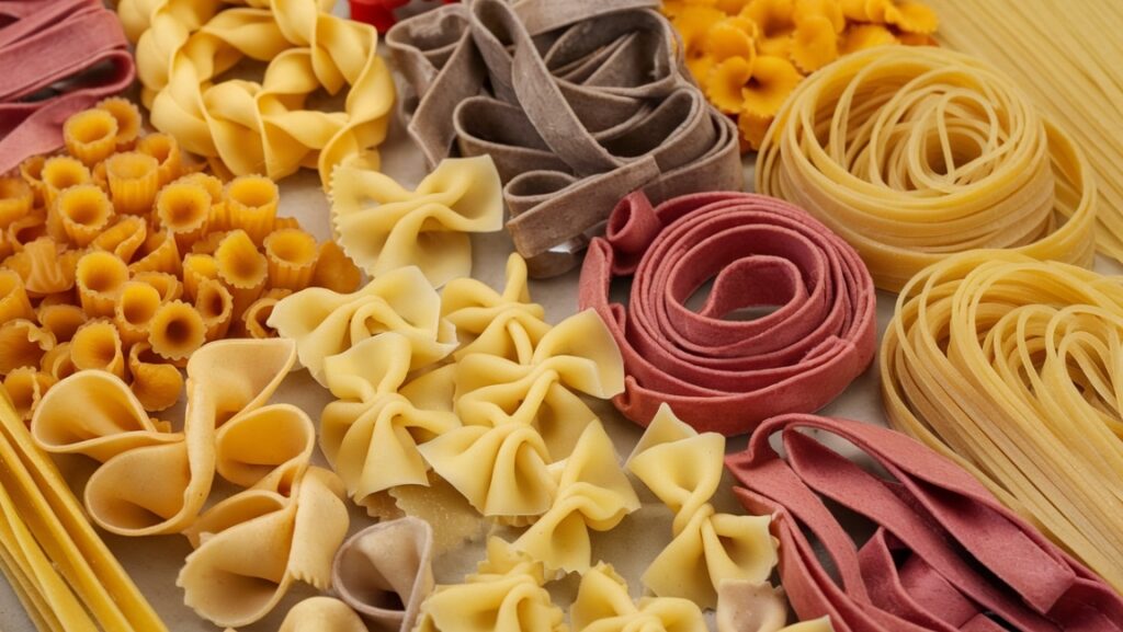 An assortment of pasta types displayed in a colorful arrangement: pappardelle