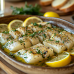 Mediterranean table with boquerones, olive oil, lemon slices, and bread on a rustic wooden table.